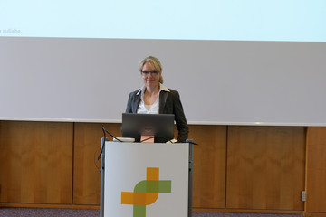 Eine Rednerin steht am Rednerpult mit einem Kreuzband-Logo der Immanuel Albertinen Diakonie vor einer Leinwand bei der Fachveranstaltung 11. Amalie Tag der Hausärztinnen und Hausärzte im Evangelischen Amalie Sieveking Krankenhaus in Hamburg-Volksdorf. Eine Rednerin steht am Rednerpult mit einem Kreuzband-Logo der Immanuel Albertinen Diakonie vor einer Leinwand bei der Fachveranstaltung 11. Amalie Tag der Hausärztinnen und Hausärzte im Evangelischen Amalie Sieveking Krankenhaus in Hamburg-Volksdorf.