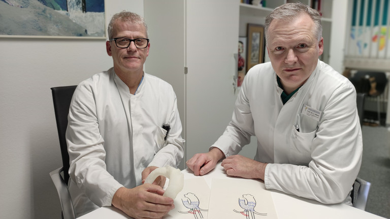 Dr. Michael Erb und Prof. Dr. Johannes Albes sitzend am Tisch, Pressefoto, Neue Gefäßprothese erspart offene Operation an der Hauptschlagader im Brustbereich, Immanuel Klinikum Bernau Herzzentrum Brandenburg, Bernau bei Berlin