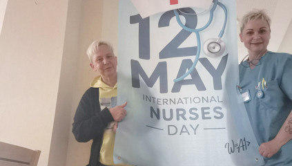 Zwei Pflegekräfte stehen um ein großes Banner mit der Aufschrift "12 May - International Nurses Day" im Immanuel Krankenhaus Berlin in Berlin-Wannsee am Internationalen Tag der Pflegenden.