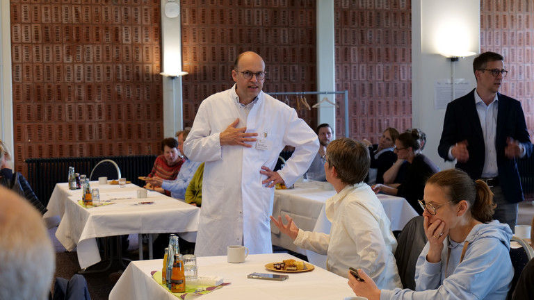 Prof. Dr. med. Ernst von Dobschütz, Chefarzt Zentrum für Endokrine Chirurgie und Ärztlicher Direktor, steht im Vortragsraum und unterhält sich mit einer Kollegin bei der Fachveranstaltung 11. Amalie Tag der Hausärztinnen und Hausärzte im Evangelischen Amalie Sieveking Krankenhaus in Hamburg-Volksdorf. Prof. Dr. med. Ernst von Dobschütz, Chefarzt Zentrum für Endokrine Chirurgie und Ärztlicher Direktor, steht im Vortragsraum und unterhält sich mit einer Kollegin bei der Fachveranstaltung 11. Amalie Tag der Hausärztinnen und Hausärzte im Evangelischen Amalie Sieveking Krankenhaus in Hamburg-Volksdorf.